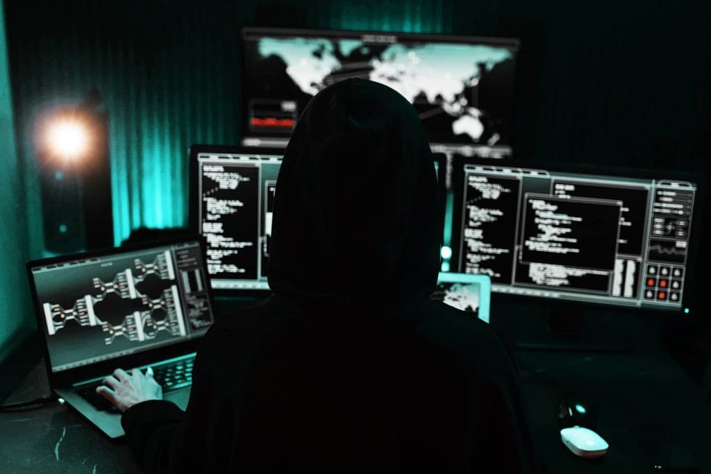 Fotografie stoc: siluetă a unui hacker cu glugă într-un mediu întunecat